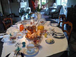a table with a table set with food and drinks at LES Roses Trémières in Gémozac