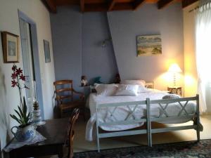 a bedroom with a bed and a table and chairs at LES Roses Trémières in Gémozac