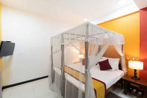 a bedroom with a bed with a canopy at Urban Kandy City Hotel in Kandy