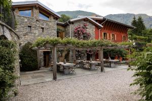 a house with an outdoor patio with tables and flowers at Agriturismo Treterre in Pianello Del Lario