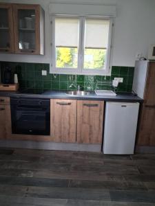a kitchen with a sink and a refrigerator at Maison du causse in Magalas