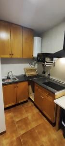 a kitchen with wooden cabinets and a sink at Cueva de David in Guadix