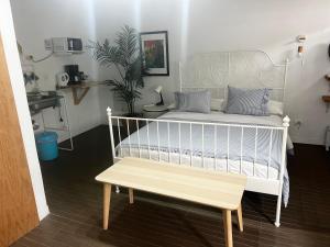 a white bed with a bench in a room at La SELVITA in Bajamar
