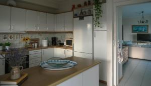 a kitchen with white cabinets and a white refrigerator at Spacious Residence in Rafina with Panoramic Views in Rafina
