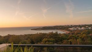 a view of a beach and the ocean at sunset at Spacious Residence in Rafina with Panoramic Views in Rafina +11 photos