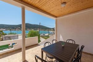 a table and chairs on a balcony with a view of the water at Holiday Home Vala in Vinišće