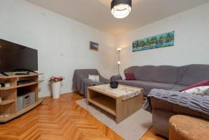a living room with a couch and a table at Holiday Home Vala in Vinišće