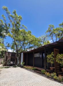 a house with a patio and trees in front of it at Pousada Encantos do Estaleiro in Balneário Camboriú