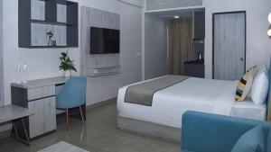a hotel room with a bed and a desk and a television at Iconic Studio Apartment in Jaipur in Jaipur