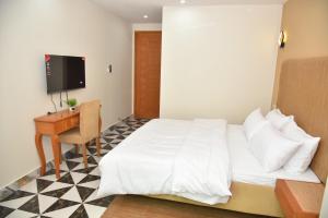 a bedroom with a bed and a desk and a television at Luxury Stay Near Neelum River Valley,208 in Muzaffarabad