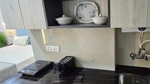 a kitchen with a counter top with a sink at Iconic Studio Apartment in Jaipur in Jaipur +12 photos
