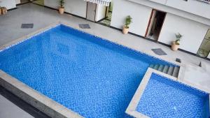 a large blue swimming pool next to a building at Iconic Studio Apartment in Jaipur in Jaipur