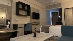 a hotel room with a bed and a desk and a table at Iconic Studio Apartment in Jaipur in Jaipur