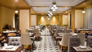 a restaurant with tables and chairs in a room at Iconic Studio Apartment in Jaipur in Jaipur