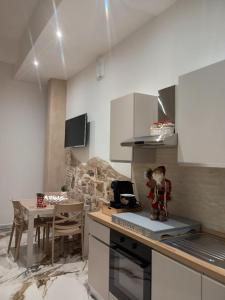 a kitchen with white cabinets and a table with a doll on the counter at LETIZIA'S HOME Caserta in Caserta