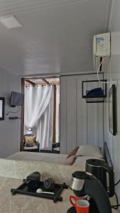 a bedroom with a bed with a window and a camera at Pousada Encantos do Estaleiro in Balneário Camboriú