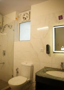a bathroom with a toilet and a sink and a window at Piyush stay in Lucknow
