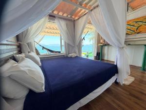 a bedroom with a canopy bed with a view of the ocean at Cabana do Mar in Angra dos Reis