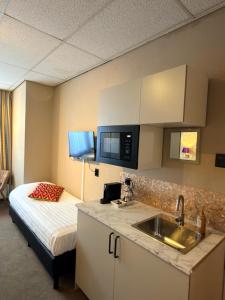 eine Küche mit Spüle und ein Bett in einem Zimmer in der Unterkunft Hotel De Stern in Scheveningen