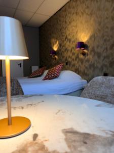 ein Hotelzimmer mit zwei Betten und einem Tisch mit Lampe in der Unterkunft Hotel De Stern in Scheveningen
