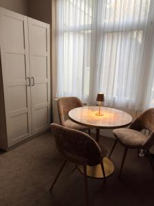ein Zimmer mit Tisch und Stühlen und einem Fenster in der Unterkunft Hotel De Stern in Scheveningen