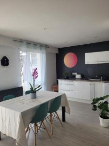 a kitchen and dining room with a table and chairs at Charmant appartement et jardin in Saint-Ismier +5 photos