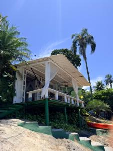 a house on the beach with palm trees at Cabana do Mar in Angra dos Reis