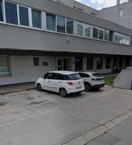 two cars parked in a parking lot in front of a building at LA MAR Apartment Spinea in Spinea
