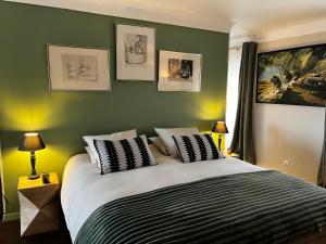 a bedroom with a large bed with green walls at Les Trois soleils in Roquebrune-sur-Argens +23 photos