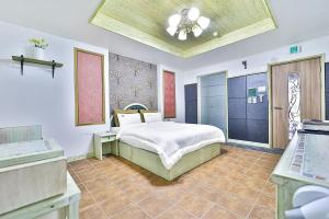 a bedroom with a bed and a ceiling at 필사랑무인텔 in Wŏndang-gol