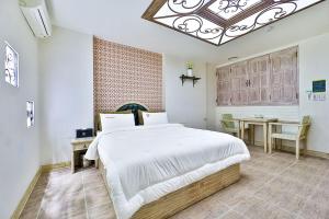 a bedroom with a large bed and a table at 필사랑무인텔 in Wŏndang-gol