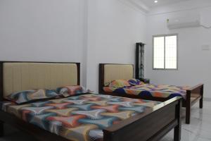 two beds sitting in a room withthritisthritis at Anand Classic in Thiruchendur