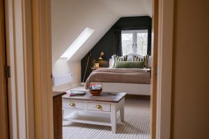 a bedroom with a bed and a window and a table at Roost in Heyshott in Midhurst