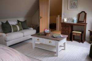 a living room with a couch and a table at Roost in Heyshott in Midhurst