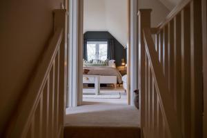 a hallway leading to a bedroom with a bed at Roost in Heyshott in Midhurst