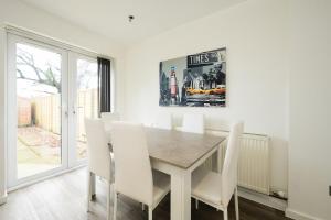 a dining room with a table and white chairs at Comfortable 3-BR House in Malvern Link