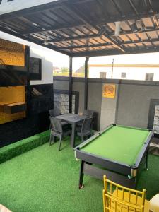 eine Tischtennisplatte und Stühle auf einer Terrasse in der Unterkunft ZAPHOMEs in Asaba + 3 Fotos