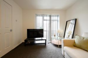 a living room with a couch and a television at Comfortable 3-BR House in Malvern Link