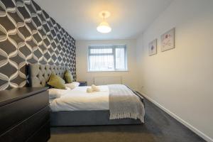 a bedroom with a large bed with a large headboard at Comfortable 3-BR House in Malvern Link