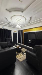 ein Wohnzimmer mit Sofas und einem Fernseher in der Unterkunft ZAPHOMEs in Asaba