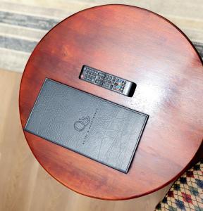 a remote control sitting on top of a wooden table at Q's Evander Hotel & Apartments in Evander