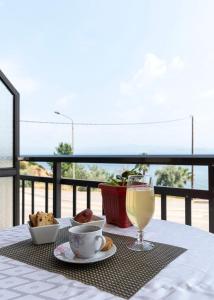 a table with a plate of food and a glass of champagne at Kiwi Kastle in Nea Fokea