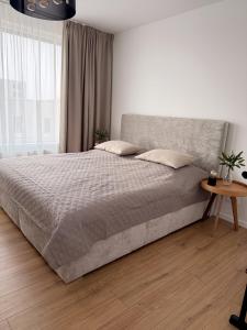 a bedroom with a large bed and a table at apartman Sole in Trnava