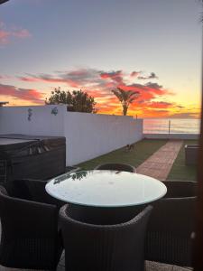 a table and chairs on a balcony with a sunset at CHALET directo al MAR in Benicarló