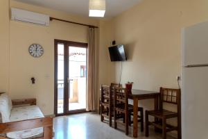 a kitchen with a table and chairs and a clock on the wall at Kiwi Kastle in Nea Fokea