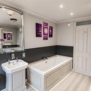a bathroom with a large white tub and a sink at The Railway Sleeper Lodge in Colchester +47 photos