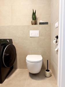 a bathroom with a toilet and a plant at apartman Sole in Trnava +9 photos