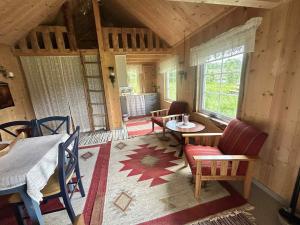 a living room with a table and chairs in a cabin at Cozy Off-Grid Cabin - No Power, No Running Water in Skretteberg