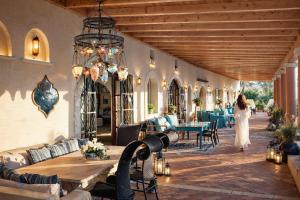 a woman in a white dress walking through a patio at Palazzo Navarone in Lindos