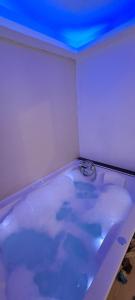 a white bath tub with a blue ceiling at Chambre bain balneo indépendante in Valréas +7 photos